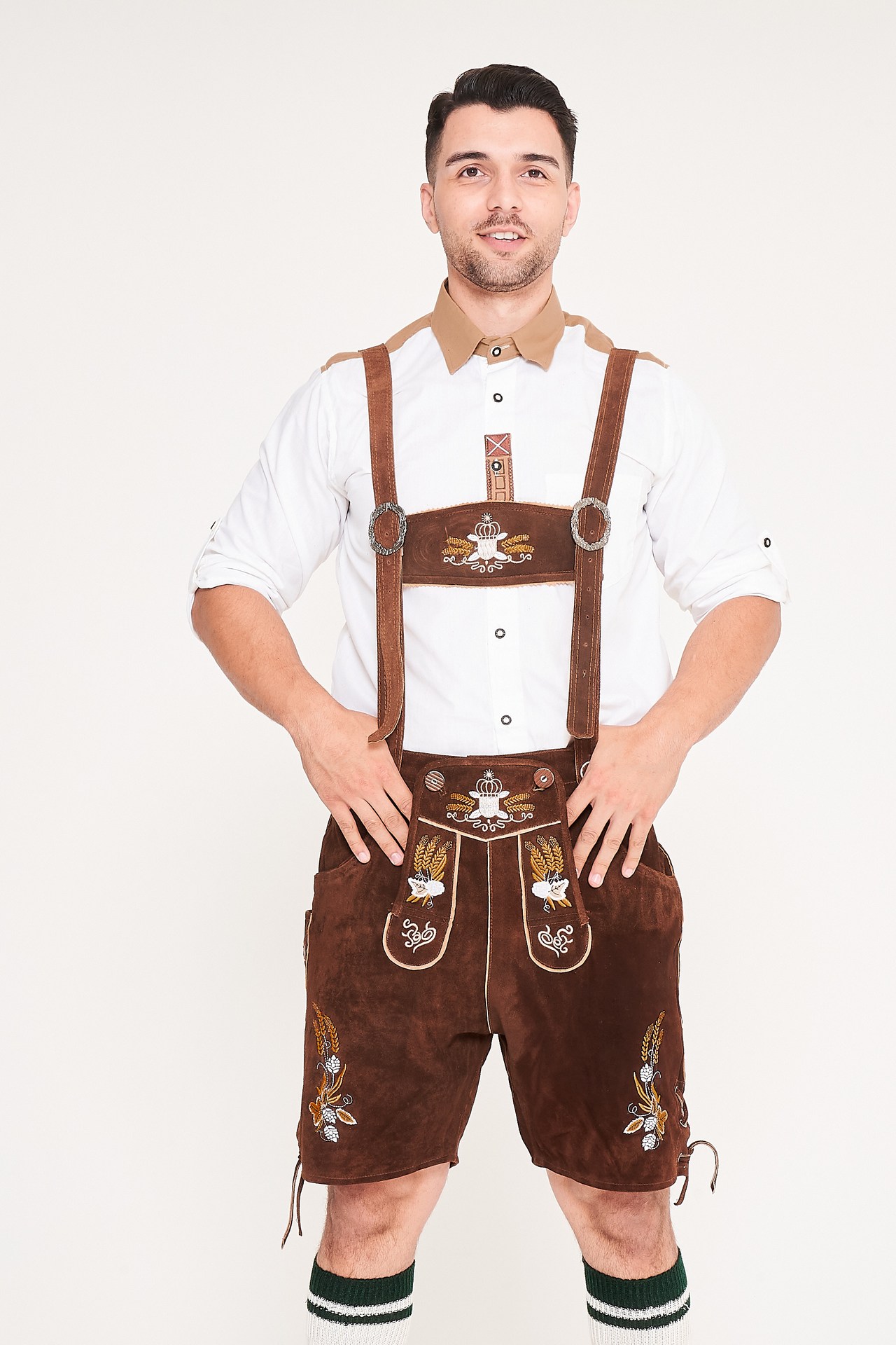 Man wearing dark brown embroidered Lederhosen with suspenders and a white shirt with tan collar accents. - Lederhosen For Sale